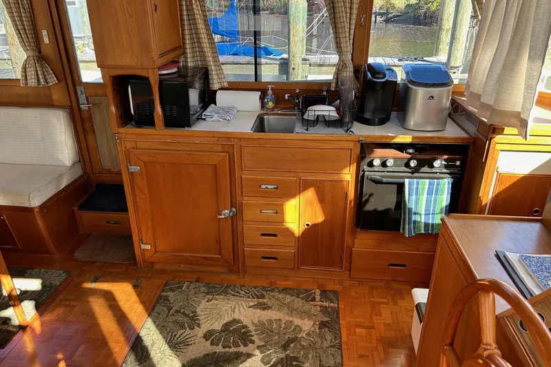 Slide: The Image of 1986 Grand Banks 42 Classic yacht interior with wooden cabinetry and kitchen appliances. - 24