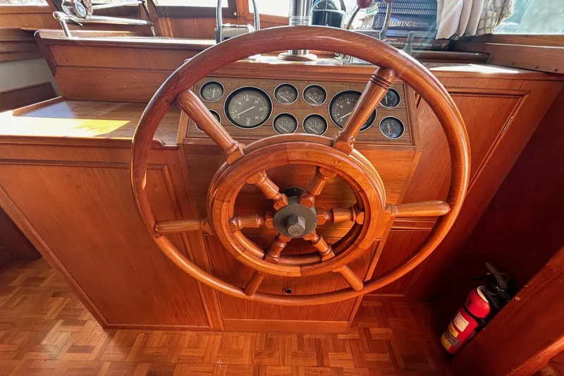 Slide: The Image of Wooden helm of 1986 Grand Banks 42 Classic yacht with gauges and fire extinguisher. - 31