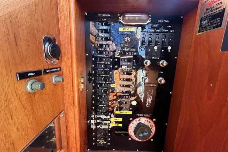 Slide: The Image of Control panel of a 1986 Grand Banks 42 Classic yacht, featuring various switches and dials. - 35