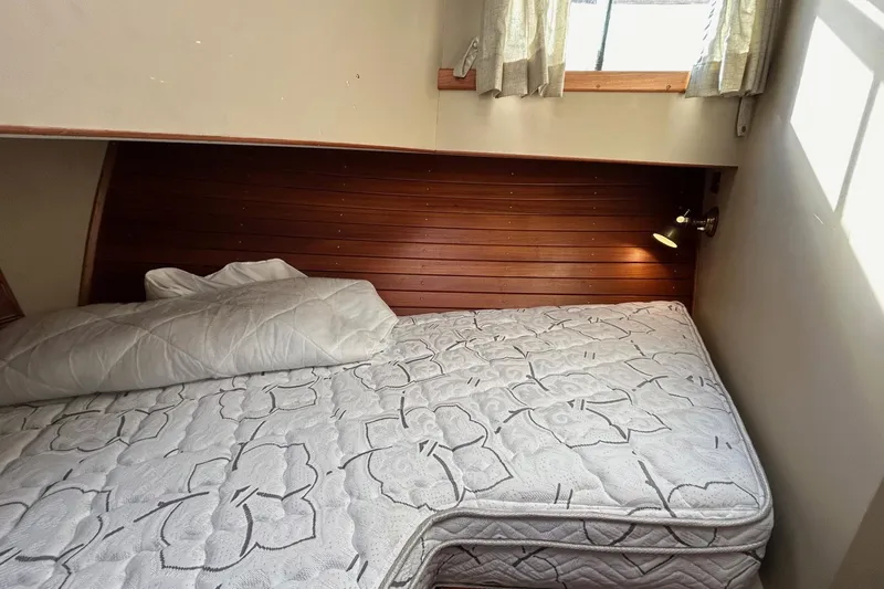 Slide: The Image of Cozy cabin bed in 1986 Grand Banks 42 Classic yacht with wooden paneling and window. - 46