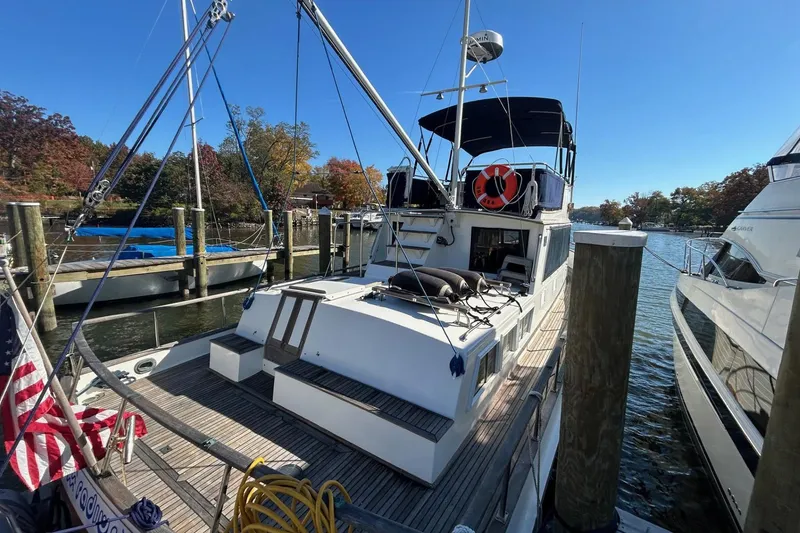 Slide: The Image of 1986 Grand Banks 42 Classic yacht docked at a marina, featuring a spacious deck and canopy. - 5