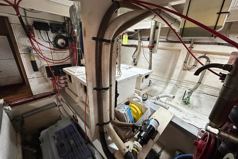 Slide: The Image of Engine room of a 1986 Grand Banks 42 Classic boat, featuring various mechanical components and wiring. - 58