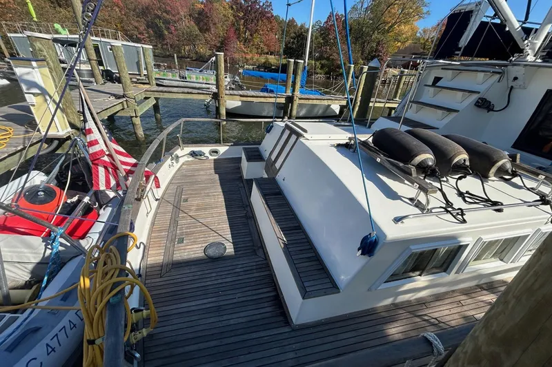 Slide: The Image of 1986 Grand Banks 42 Classic yacht docked, featuring wooden deck and American flag. - 6