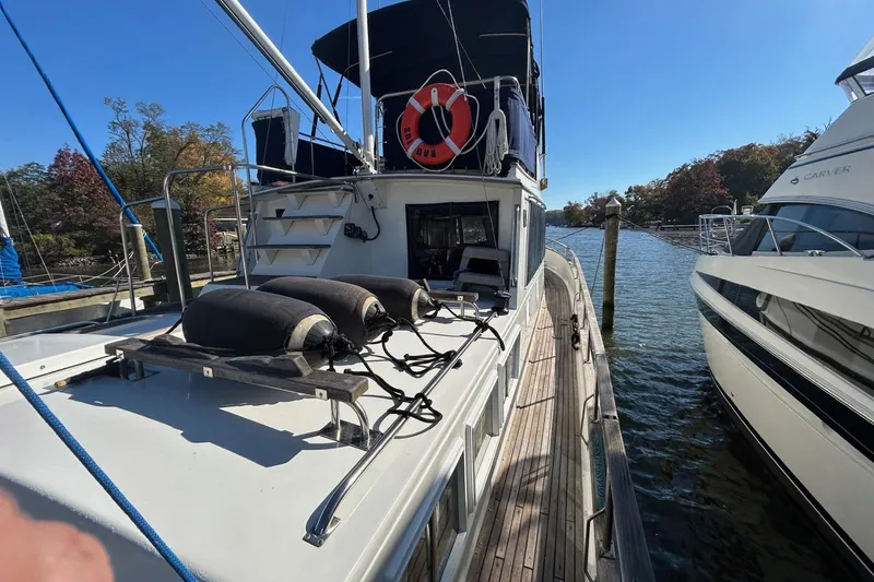 Slide: The Image of 1986 Grand Banks 42 Classic yacht docked, featuring deck equipment and lifebuoy. - 9