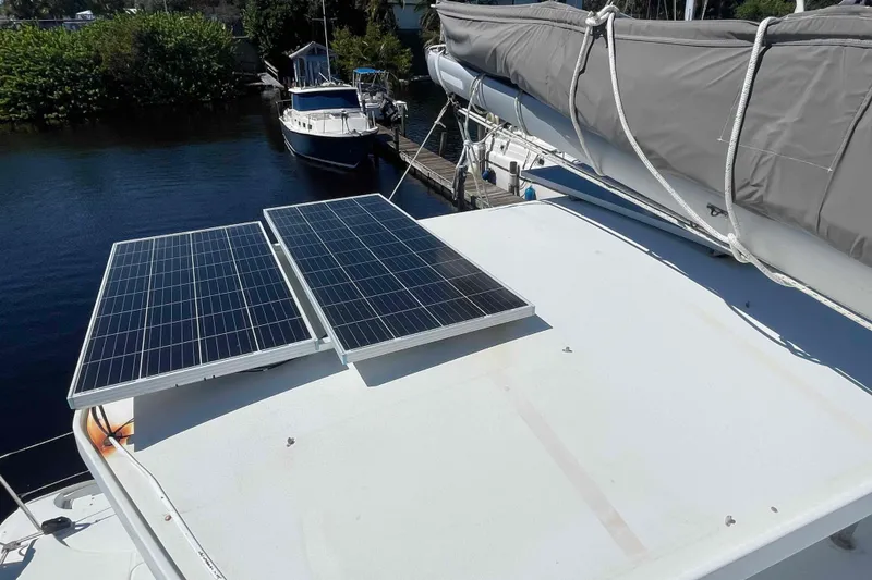 Slide: The Image of Solar panels on 2003 Lagoon 410-S2 catamaran docked by water. - 21
