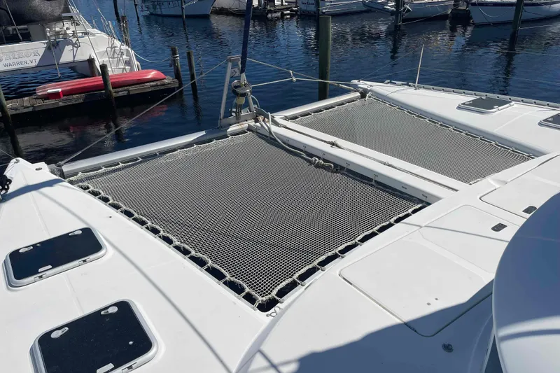 Slide: The Image of 2003 Lagoon 410-S2 catamaran with netted deck, docked at marina. - 24