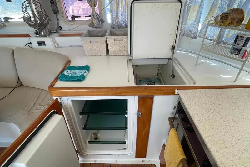 Slide: The Image of Interior of 2003 Lagoon 410-S2 catamaran with cozy seating, kitchen, and wooden flooring. - 39