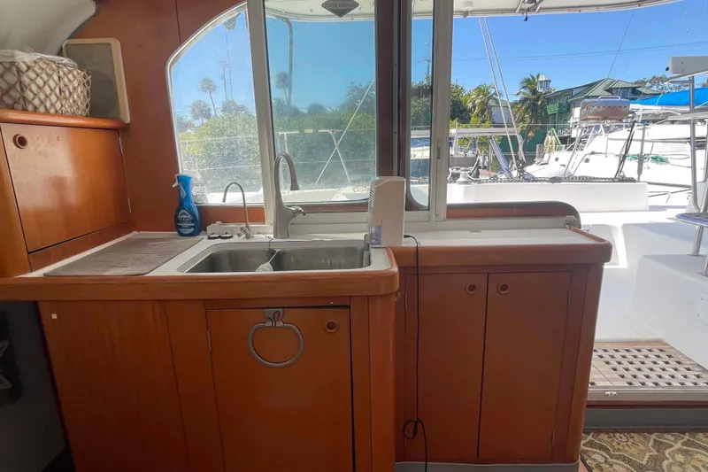 Slide: The Image of Compact kitchen area in a 2003 Lagoon 410-S2 yacht with stove and kettle. - 42