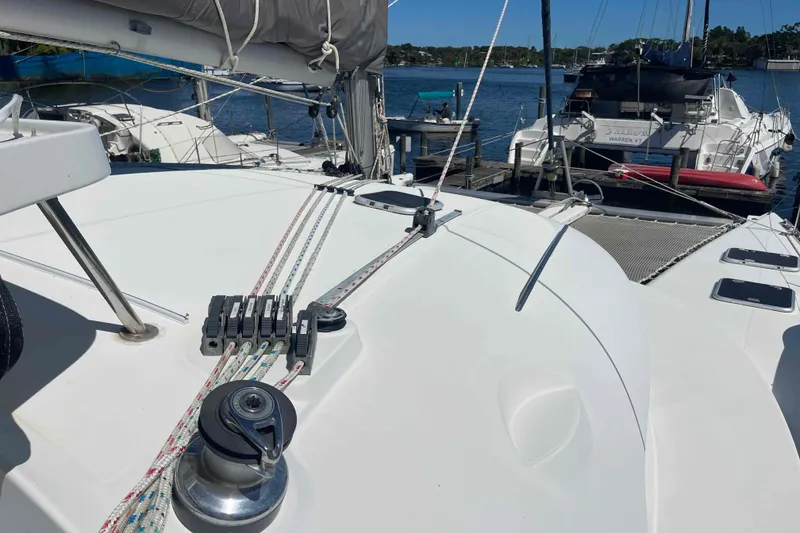 Slide: The Image of Front deck of a 2003 Lagoon 410-S2 catamaran with netting and hatches. - 63