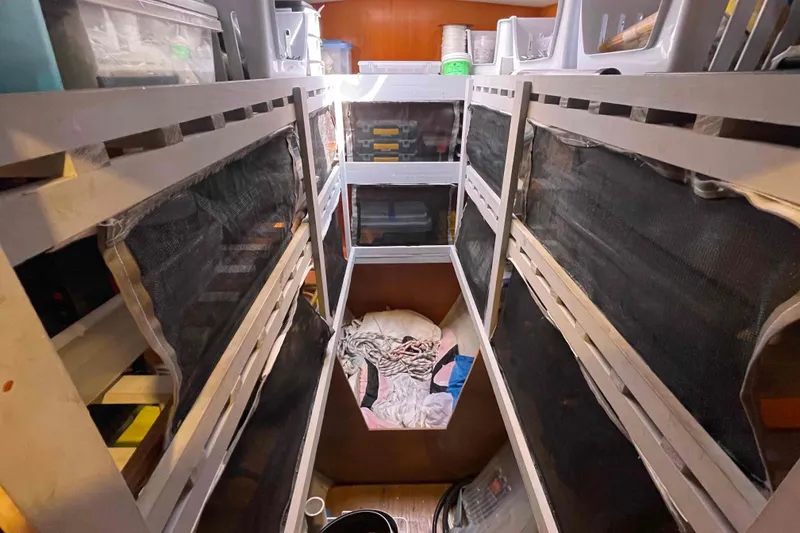 Slide: The Image of Interior storage area of a 2003 Lagoon 410-S2 catamaran with organized shelves and supplies. - 11