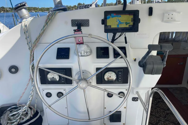 Slide: The Image of Steering wheel and navigation controls on a 2003 Lagoon 410-S2 catamaran. - 16