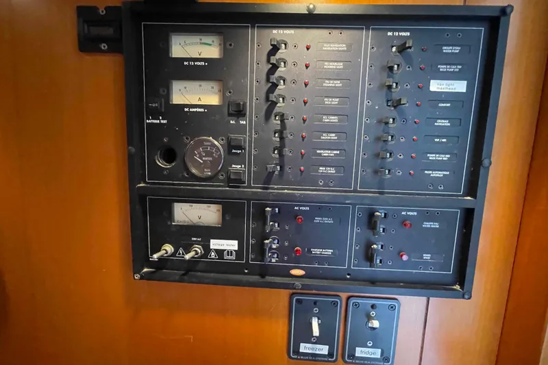 Slide: The Image of Electrical control panel on a 2003 Lagoon 410-S2 yacht, featuring various switches and gauges. - 25