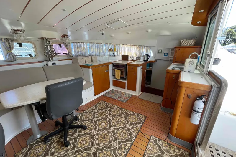 Slide: The Image of Interior view of 2003 Lagoon 410-S2 catamaran, featuring helm and spacious cabin. - 37