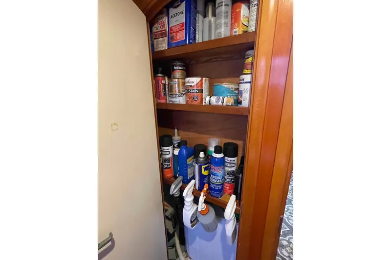 Slide: The Image of Open cabinet in 2003 Lagoon 410-S2 yacht with kitchen utensils and cookware. - 52
