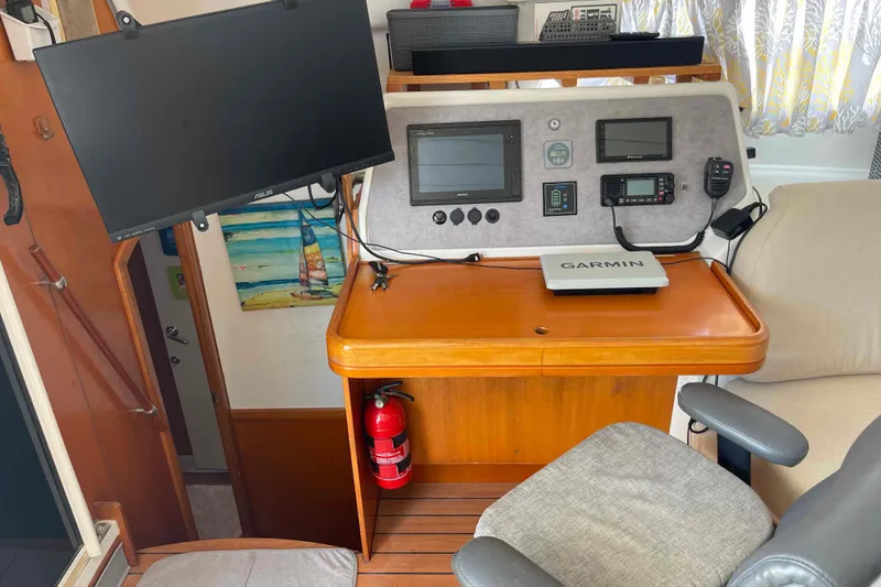 Slide: The Image of Navigation station of 2003 Lagoon 410-S2 catamaran with Garmin equipment and fire extinguisher. - 6
