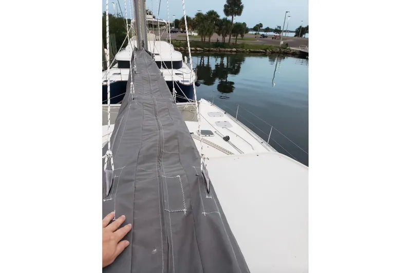 Slide: The Image of Colorful sail on 2003 Lagoon 410-S2 catamaran against blue sky and ocean backdrop. - 82