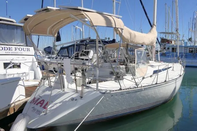 The Image of 1989 C&C 37/40+ sailboat docked in marina, featuring beige canopy and sleek design. - 1