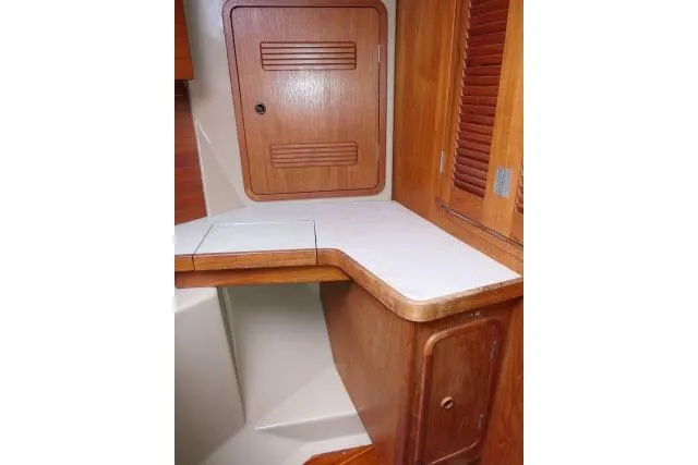 Slide: The Image of 1989 C&C 37/40+ yacht interior with wooden cabinetry and white countertop. - 28