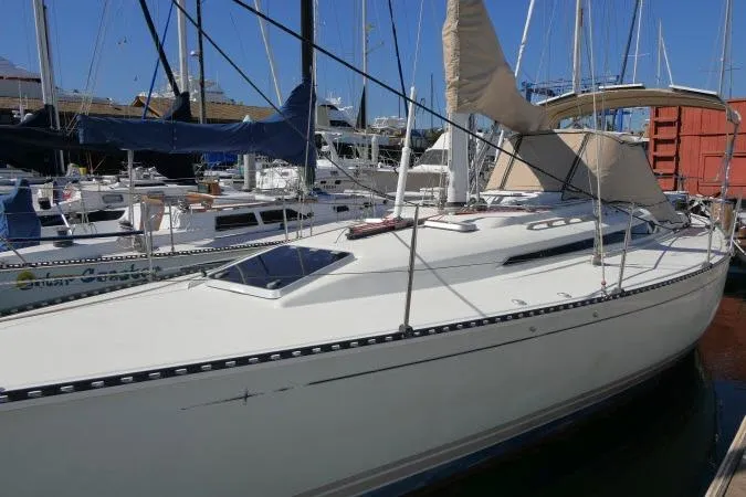 Slide: The Image of 1989 C&C 37/40+ sailboat docked in marina, featuring sleek white hull and covered sails. - 55