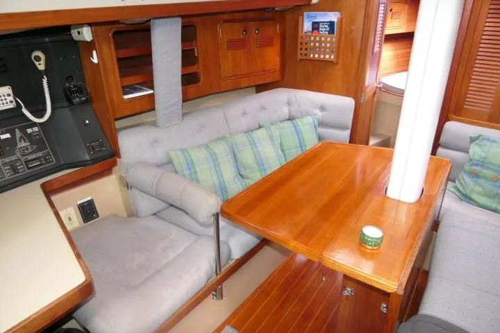 Slide: The Image of Cozy interior of 1989 C&C 37/40+ sailboat with wooden table and cushioned seating. - 6