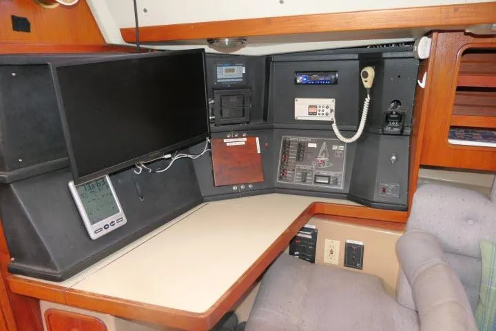 Slide: The Image of Navigation station inside a 1989 C&C 37/40+ sailboat, featuring control panels and communication equipment. - 14