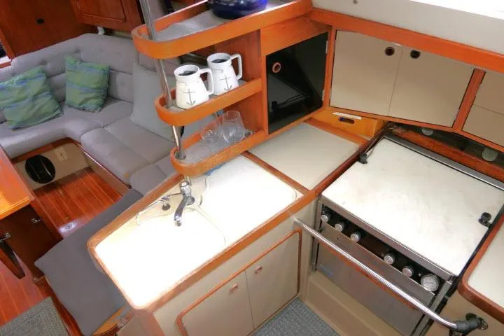 Slide: The Image of 1989 C&C 37/40+ yacht interior with kitchen, stove, and cozy seating area. - 15