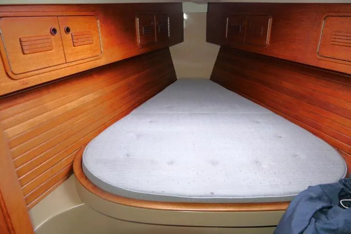 Slide: The Image of 1989 C&C 37/40+ sailboat interior with wooden paneling and a V-berth bed. - 23