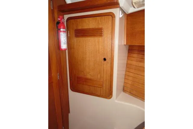 Slide: The Image of Wooden cabinet door inside 1989 C&C 37/40+ sailboat with fire extinguisher nearby. - 24