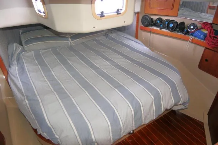 Slide: The Image of Cozy cabin interior of 1989 C&C 37/40+ sailboat with striped bedding and wooden flooring. - 29
