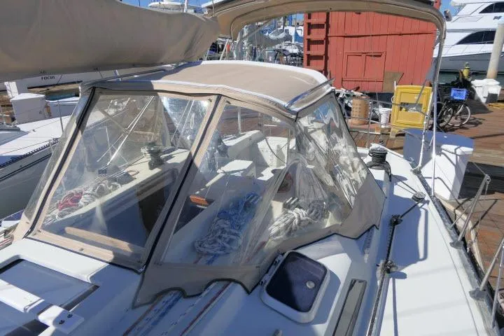 Slide: The Image of 1989 C&C 37/40+ sailboat with beige canopy docked at marina. - 44