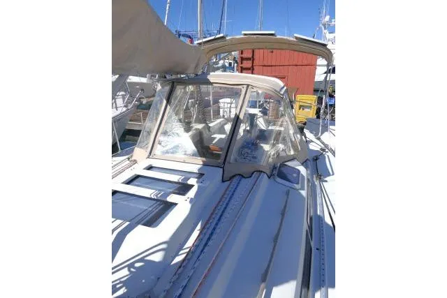 Slide: The Image of 1989 C&C 37/40+ sailboat with cockpit cover, docked at marina under clear blue sky. - 46