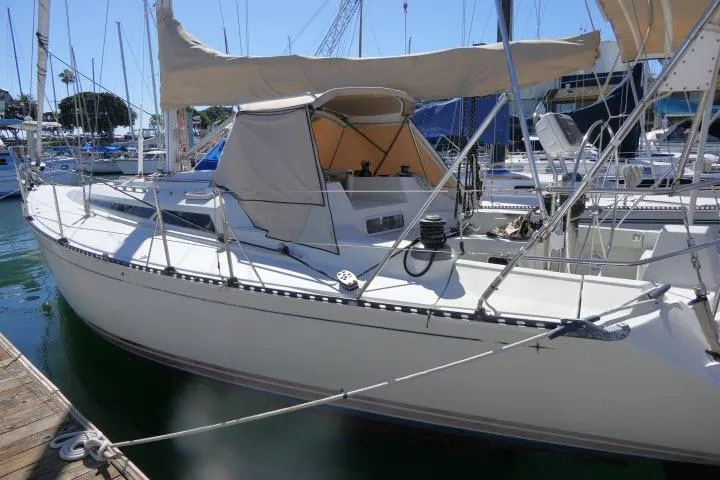 Slide: The Image of 1989 C&C 37/40+ sailboat docked at marina, featuring beige canopy and sleek design. - 57