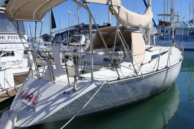 Slide: The Image of 1989 C&C 37/40+ sailboat docked in marina, featuring sleek design and beige canopy. - 58