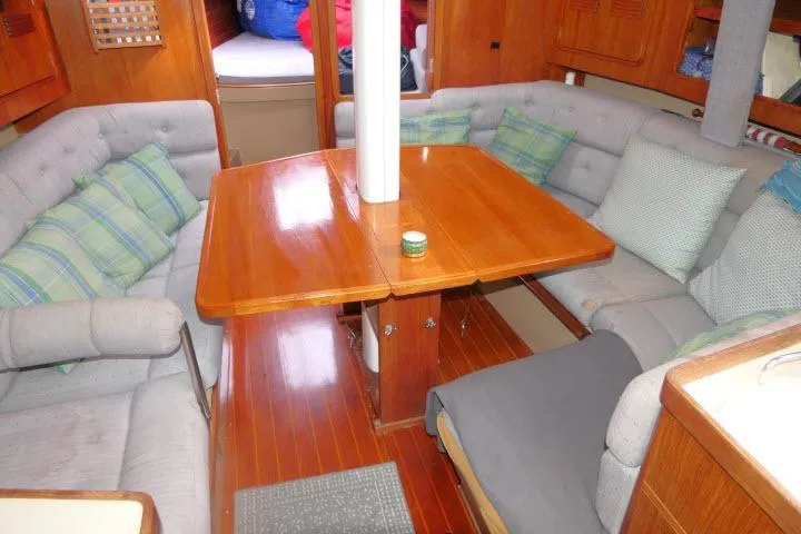 Slide: The Image of 1989 C&C 37/40+ yacht interior with wooden table, cushioned seating, and cozy decor. - 7