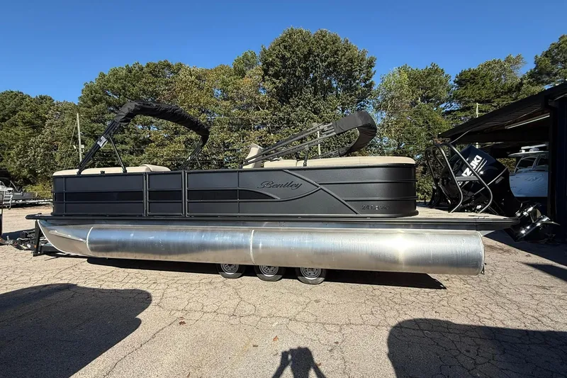 Slide: The Image of 2026 Bentley Pontoons Legacy 243 Navigator, black exterior, parked outdoors on a sunny day. - 2