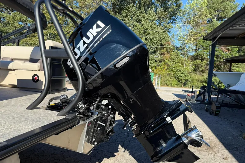 Slide: The Image of 2026 Bentley Pontoons Legacy 243 Navigator with Suzuki outboard motor in a sunny outdoor setting. - 4