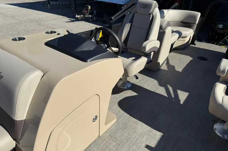 Slide: The Image of 2026 Bentley Pontoons Legacy 243 Navigator interior with beige seating and steering console. - 8