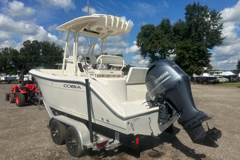 Slide: The Image of 2023 Cobia 220 Center Console boat with Yamaha engine on trailer, outdoors. - 11