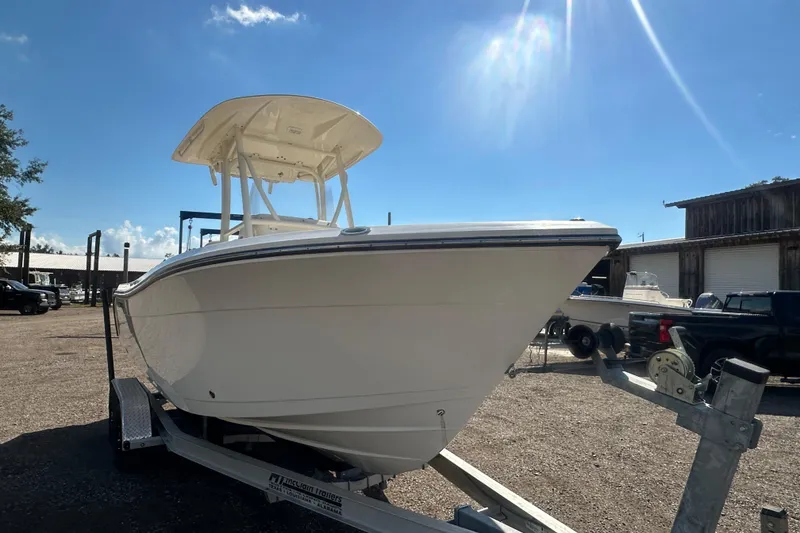 Slide: The Image of 2023 Cobia 220 Center Console boat on trailer under clear blue sky. - 17
