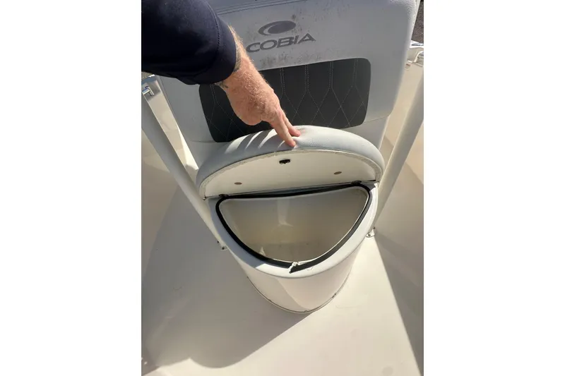 Slide: The Image of 2023 Cobia 220 Center Console seat with storage compartment open. - 23