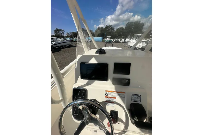 Slide: The Image of 2023 Cobia 220 Center Console boat dashboard with steering wheel and navigation screens. - 28