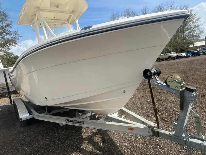 Slide: The Image of 2023 Cobia 220 CC boat on trailer, parked outdoors under blue sky. - 7