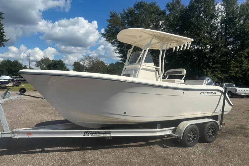Slide: The Image of 2023 Cobia 220 Center Console boat on trailer under blue sky. - 9