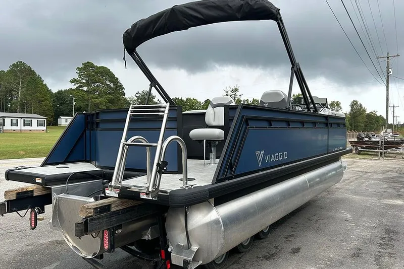 Slide: The Image of 2025 Viaggio Lago V-R pontoon boat with canopy and ladder, parked outdoors. - 5