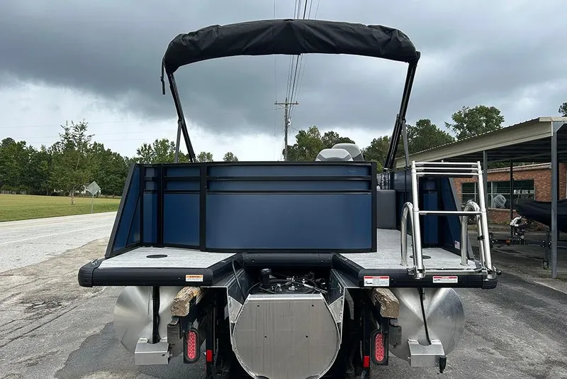 Slide: The Image of 2025 Viaggio Lago V-R pontoon boat with canopy and ladder, parked on a cloudy day. - 6