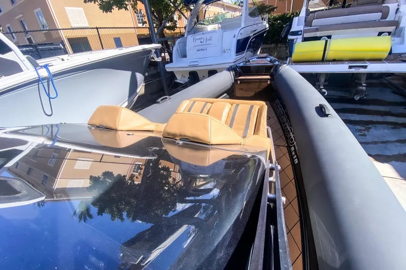 Slide: The Image of 2018 Bernico RX 10 boat with tan seats and sleek design in a marina setting. - 13