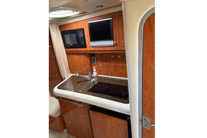 Slide: The Image of 2006 Four Winns 318 Vista boat interior with kitchenette, microwave, and TV. - 5
