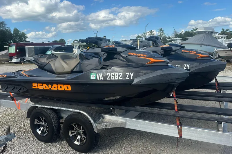 The Image of 2021 Sea-Doo GTX 300 jet skis on a trailer under a blue sky. - 1