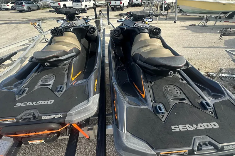 Slide: The Image of Two 2021 Sea-Doo GTX 300 jet skis parked on trailers in a lot. - 4