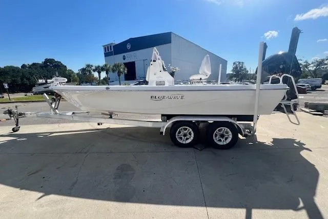 The Image of 2019 Blue Wave 2200 PureBay boat on trailer, parked outdoors under clear sky. - 1